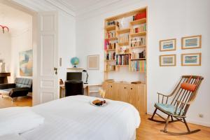 een slaapkamer met een bed, een stoel en een bureau bij Saint Catherine Art Residence in Brussel