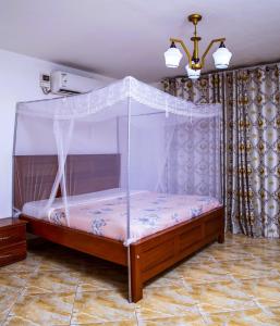 a bed with a canopy in a room at Hidden Treasure Serviced Hotel Apartments HITSHA HOTELS Entebbe in Entebbe