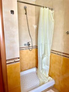 y baño con ducha con cortina blanca. en Easy Peasy - 9th floor view downtown, en Tirana
