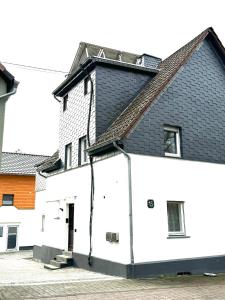 a white building with a black roof at Ferienhaus Dierdorf in Dierdorf
