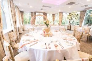 Crabwall Manor & Spa - BW Signature Collection في تشيستر: قاعة احتفالات الزفاف مع طاولات وكراسي بيضاء