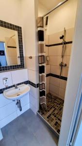 y baño con lavabo y ducha. en Am Lindenhof - Self Check-In Hotel, en Hannover