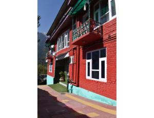 een rood bakstenen gebouw met een balkon in een straat bij Pine View Resort, Pahalgam in Pahalgām