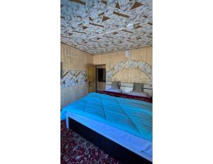 een slaapkamer met een blauw bed en een schuin plafond bij Pine View Resort, Pahalgam in Pahalgām