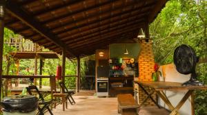 an outdoor kitchen with a table and a stove at Cabana do Tarzan na Praia de Parati Mirim in Paraty