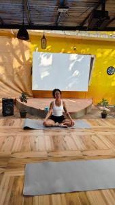 a woman sitting on the floor in a yoga class at The goanvibes hostel and cafe in Anjuna