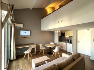 - un salon avec un canapé et une table dans l'établissement Les appartements du Clos de la Chartreuse By Ateya, à Aix-en-Provence