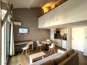 a living room with a couch and a table at Les appartements du Clos de la Chartreuse By Ateya in Aix-en-Provence
