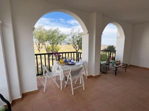 Zimmer mit einem Tisch und Stühlen auf einem Balkon in der Unterkunft Apt Diamante El Valle Golf in Baños y Mendigo