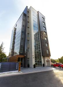 ein hohes Gebäude mit einem davor geparkt in der Unterkunft Hotel Heritage in Belgrad