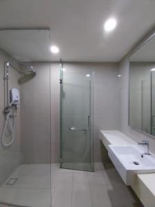 a bathroom with a glass shower and a sink at KL Gateway Residency in Kuala Lumpur