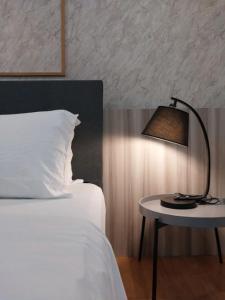 a bedroom with a bed and a table with a lamp at KL Gateway Residency in Kuala Lumpur