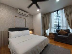 a bedroom with a large white bed and a couch at KL Gateway Residency in Kuala Lumpur