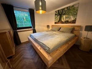 a bedroom with a wooden bed with a window at Ferienwohnung Rettbrook in Bad Zwischenahn