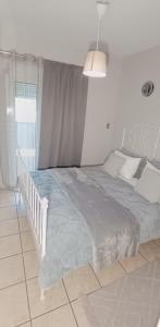 a bedroom with a large bed with a blue blanket at Georgias house 7 min from Athens airport in Artemida