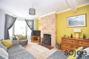 a living room with a couch and a fireplace at Charming and spacious 3 bedroom house very close to the beach in Lowestoft