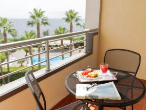 un tavolo con un cesto di frutta sul balcone di Hotel Nettuno a Catania