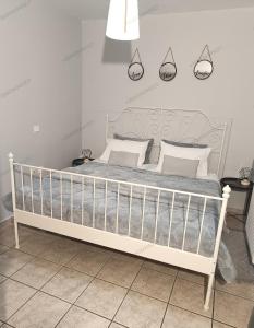 a bedroom with a white bed with white pillows at Georgias house 7 min from Athens airport in Artemida