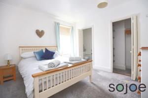 a bedroom with a large bed with blue pillows at Charming and spacious 3 bedroom house very close to the beach in Lowestoft