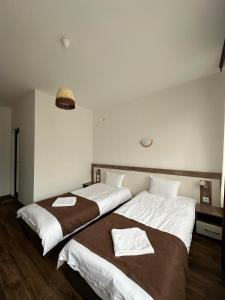 two beds in a hotel room with towels on them at Бялата Къща in Chakalarovo +46 photos