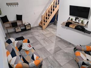 sala de estar con 2 sofás y TV de pantalla plana en Charmante maison Ardennaise, en Hampteau