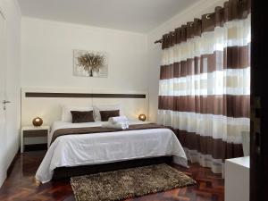 a bedroom with a large bed and a window at The Rock Guest House in Rosto de Cão