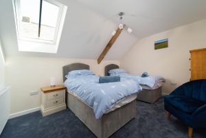 2 camas individuais num quarto com uma janela em The Old Piggery em Stoke Rivers