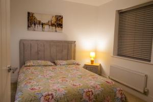 1 dormitorio con 1 cama y una foto en la pared en A1M Hampton Lakes Brand New Entire House en Peterborough