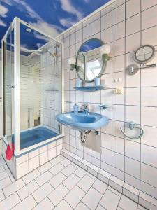 uma casa de banho com um lavatório azul e um chuveiro em Sonnendeck em Greetsiel