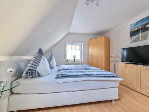 1 dormitorio con 1 cama y TV de pantalla plana en Sonnendeck en Greetsiel