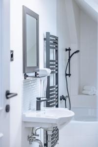 Baño blanco con lavabo y espejo en Gästehaus Remo, en Hermagor