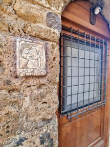 a stone wall with a door with a window at Francigena Maison in Sutri