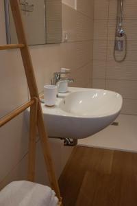 La salle de bains est pourvue d'un lavabo blanc et d'un miroir. dans l'établissement Casa Doré in South Sardinia, à Sìnnai