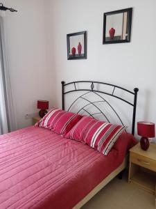 a bedroom with a red bed with two red pillows at Apartament Palm Bay View Esentepe Bahceli in Kérynia