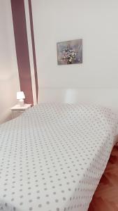 een wit bed in een slaapkamer met een foto aan de muur bij Relax in Preko