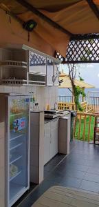 an outdoor kitchen with a refrigerator and a sink at Alshumukh guesthouse in Al Ghalīlah
