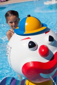 un joven en una piscina con un sombrero de construcción en un inflable en le Camping Des 3 Lacs en Belmont-Tramonet