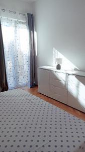 een slaapkamer met een bed, een dressoir en een raam bij Relax in Preko