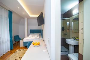 um quarto com uma cama e uma casa de banho com um lavatório em Hotel Konačište Akustik em Zlatibor