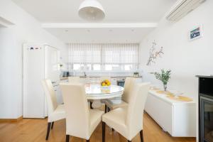 a white kitchen with a white table and chairs at Luxury residence Adriatic Pearl in Split