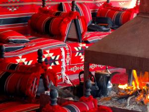 a row of red chairs sitting next to a fire at Wadi rum view camp in Wadi Rum