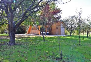 a house in a field with trees and grass at Luxury Wellnes Glamping Cottage - Salvus in Lendava