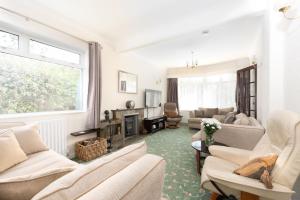 uma sala de estar com mobiliário branco e uma lareira em Talland Croft em Crantock