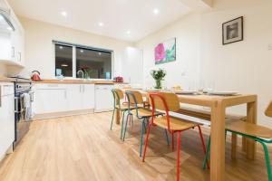 uma cozinha e sala de jantar com uma mesa de madeira e cadeiras em Talland Croft em Crantock