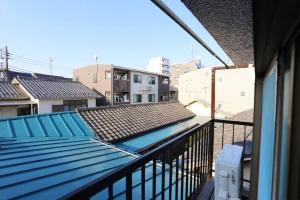 un balcon avec un toit bleu et certains bâtiments dans l'établissement JR Otsuka Station 8min/Toshima Best Area/suitable for 4-7ppl, à Tokyo