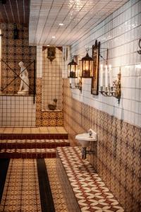 uma casa de banho em azulejo com um lavatório e um lavatório em Hotell Havanna em Varberg
