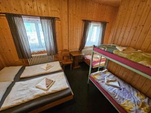 a room with three bunk beds in a cabin at Bouda Bílé Labe in Špindlerův Mlýn