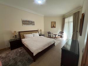 a bedroom with a bed and a table and chairs at Palm Jumeirah - Dubai 3 Bedroom Park Side - With Beach Access in Dubai