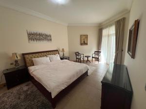 a bedroom with a bed and a table and chairs at Palm Jumeirah - Dubai 3 Bedroom Park Side - With Beach Access in Dubai