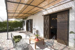 a patio with chairs and a table and a wooden pergola at B&B L' Eremo in Sulmona